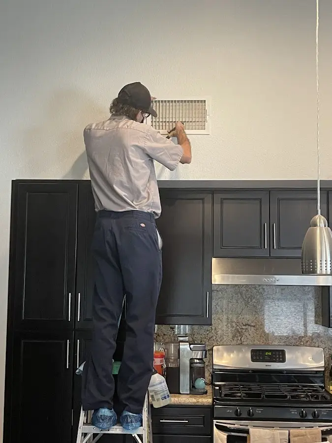 Technician inspecting an air vent during HVAC service in Fruitland
